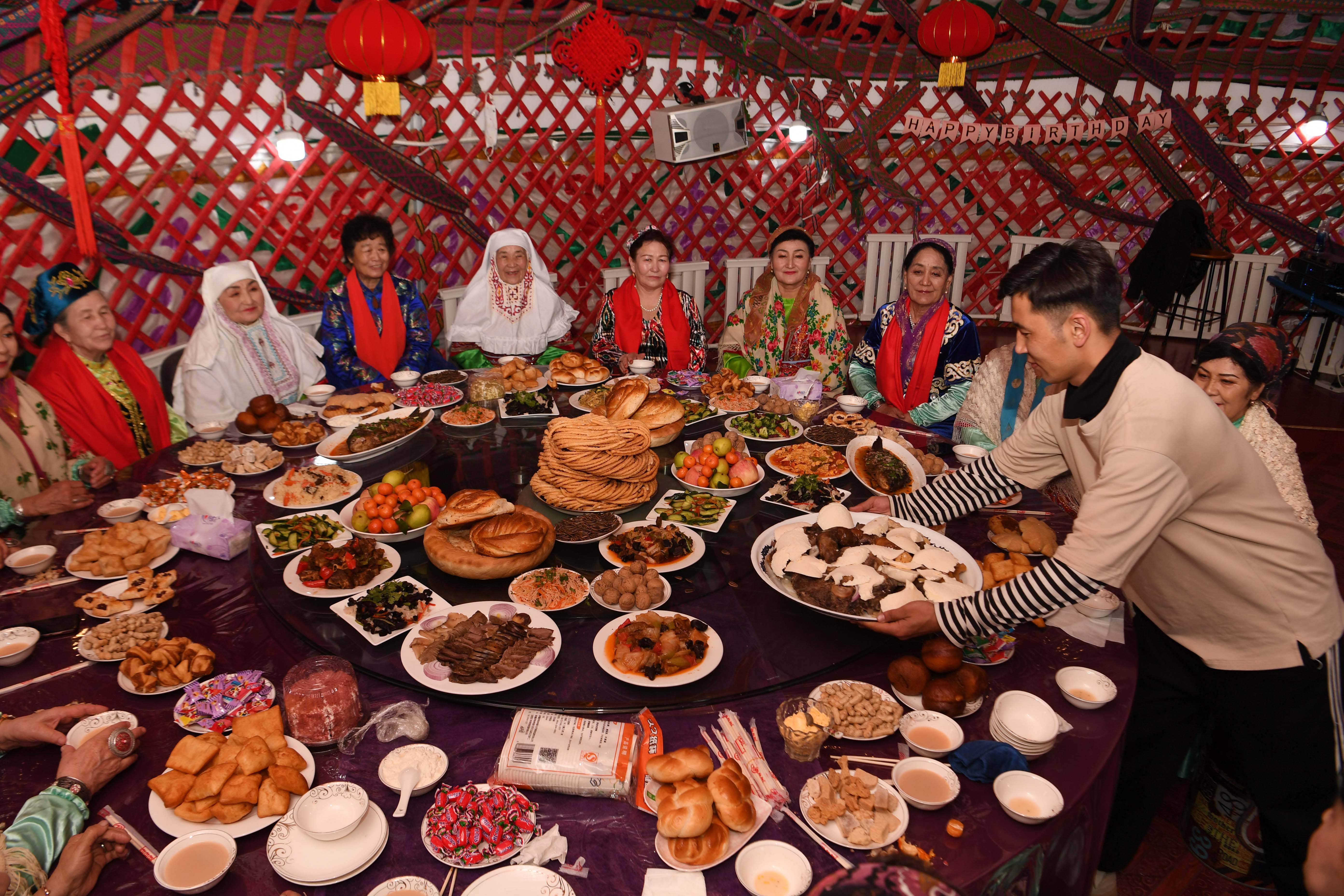 县哈萨克民宿风情自驾游基地的毡房里,民间社团的团员们一起庆祝春节