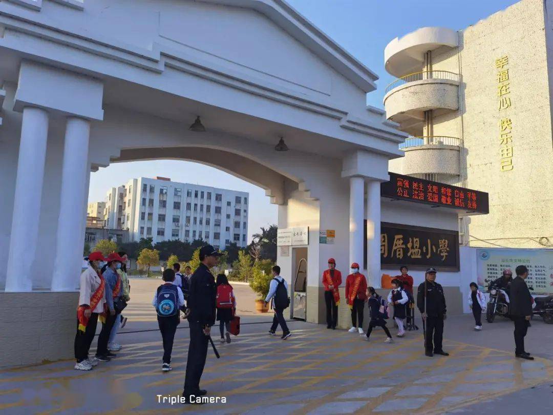 周厝塭小学教师,民警和家长志愿者在校门口进行交通疏导丽日小学警