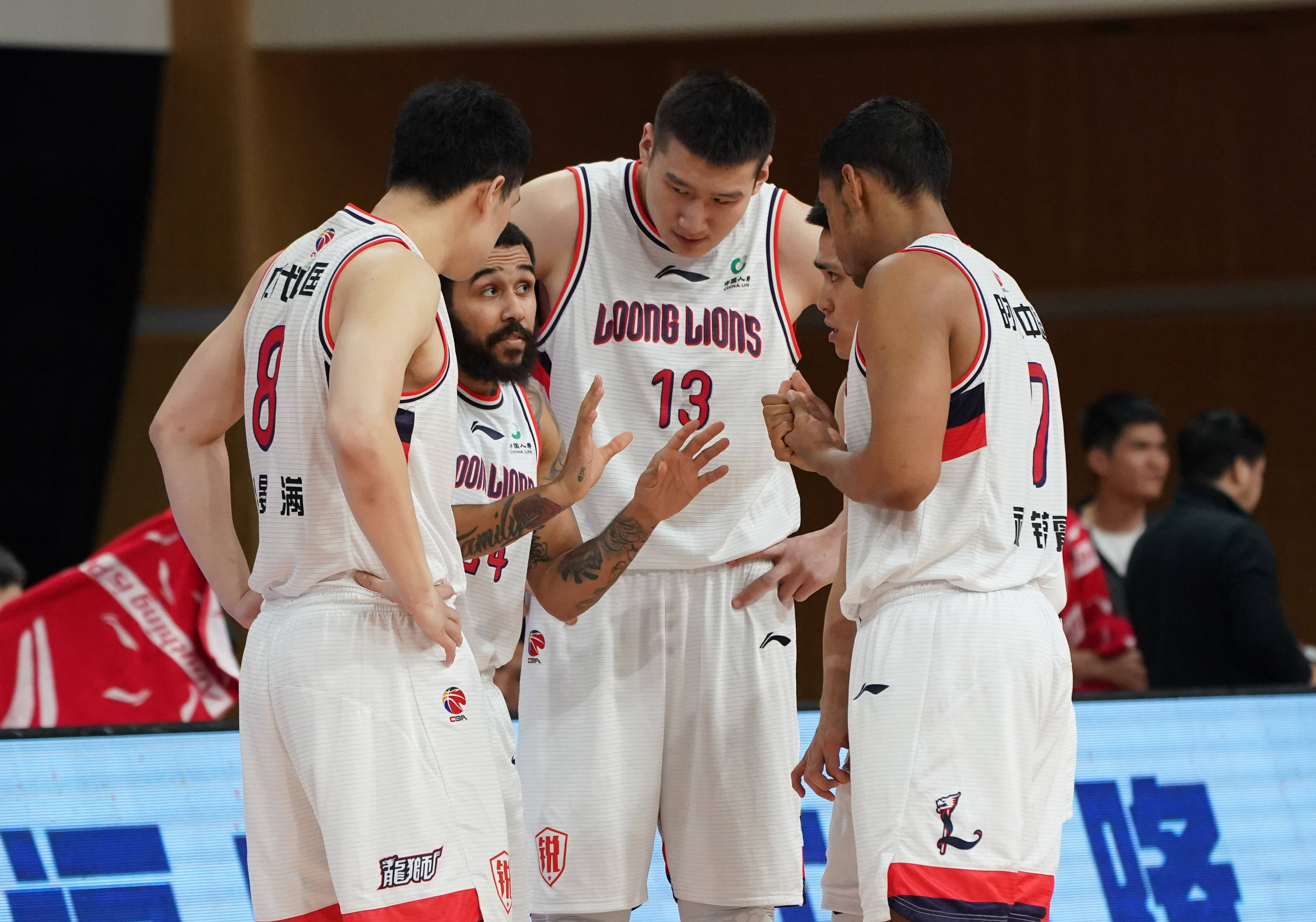 3月24日,时代中国广州队球员摩尔(左二)在比赛开始前与队友交流.