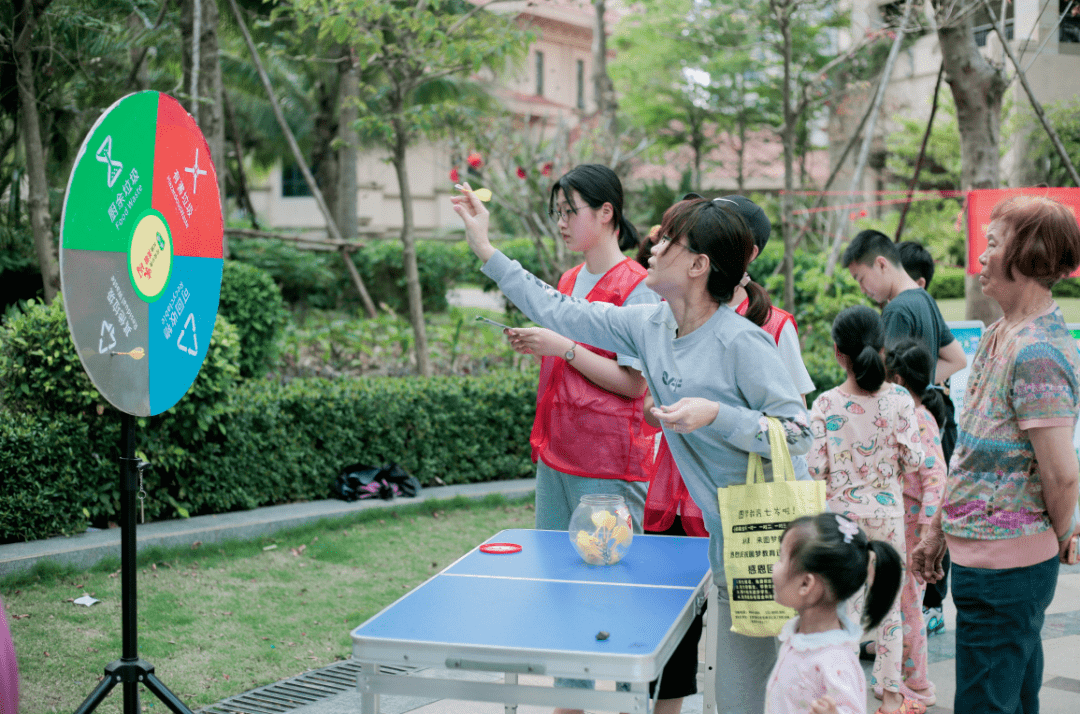 活动现场,居民们在玩垃圾分类主题的游戏,通过游园活动学习垃圾分类