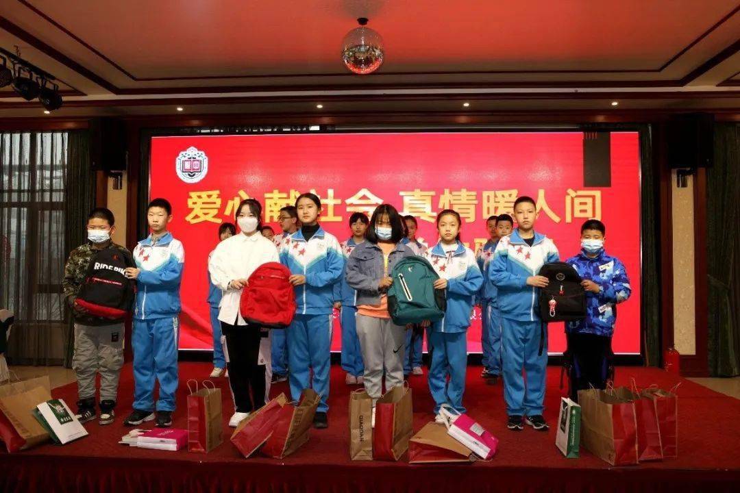 四班学生将满载爱心的学习用品送到双阳区爱国村4名贫困生怀里.