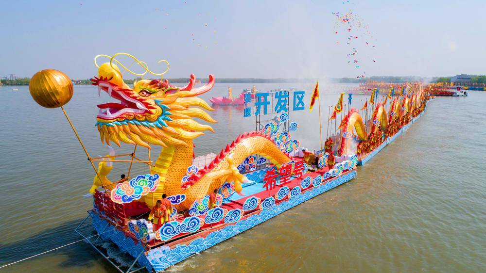 4月8日,在溱潼会船节上,选手在龙舟上舞龙.