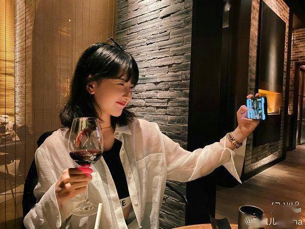 红唇配齐刘海发型气场十足,其中一张照片宋祖儿手捧红酒杯对镜自拍