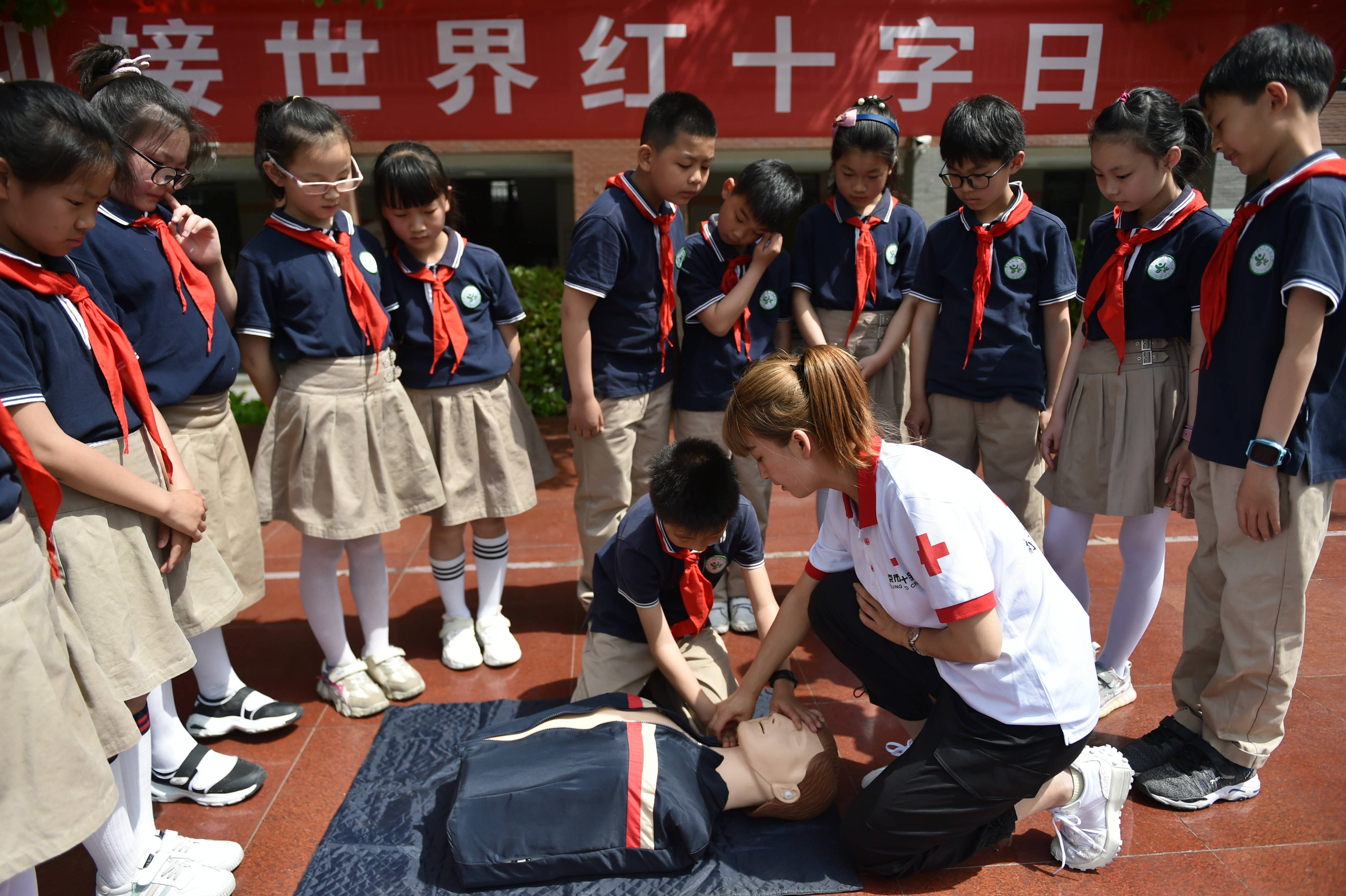 在江苏省南京市光华东街小学,学生在南京市红十字会工作人员的指导下