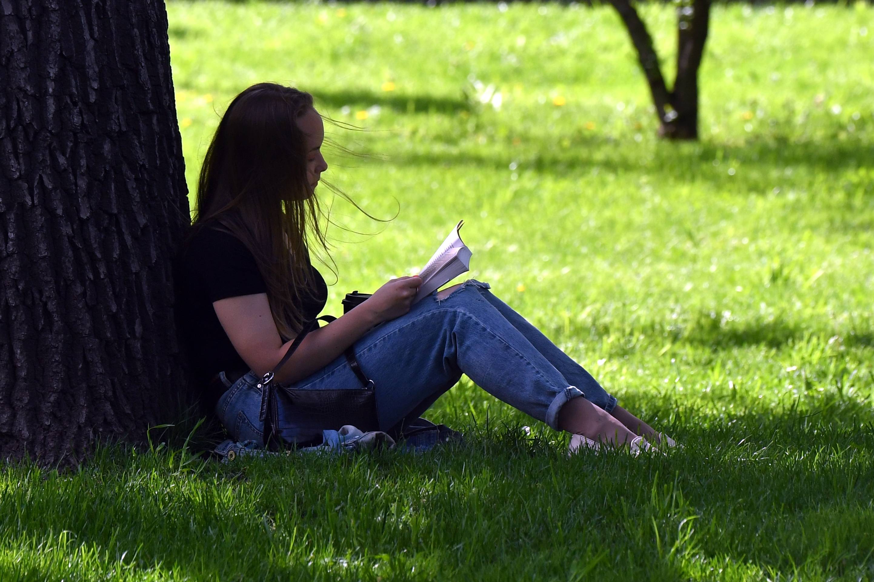 外代,2021年5月17日 5月15日,一名女子在俄罗斯莫斯科的草地上看书