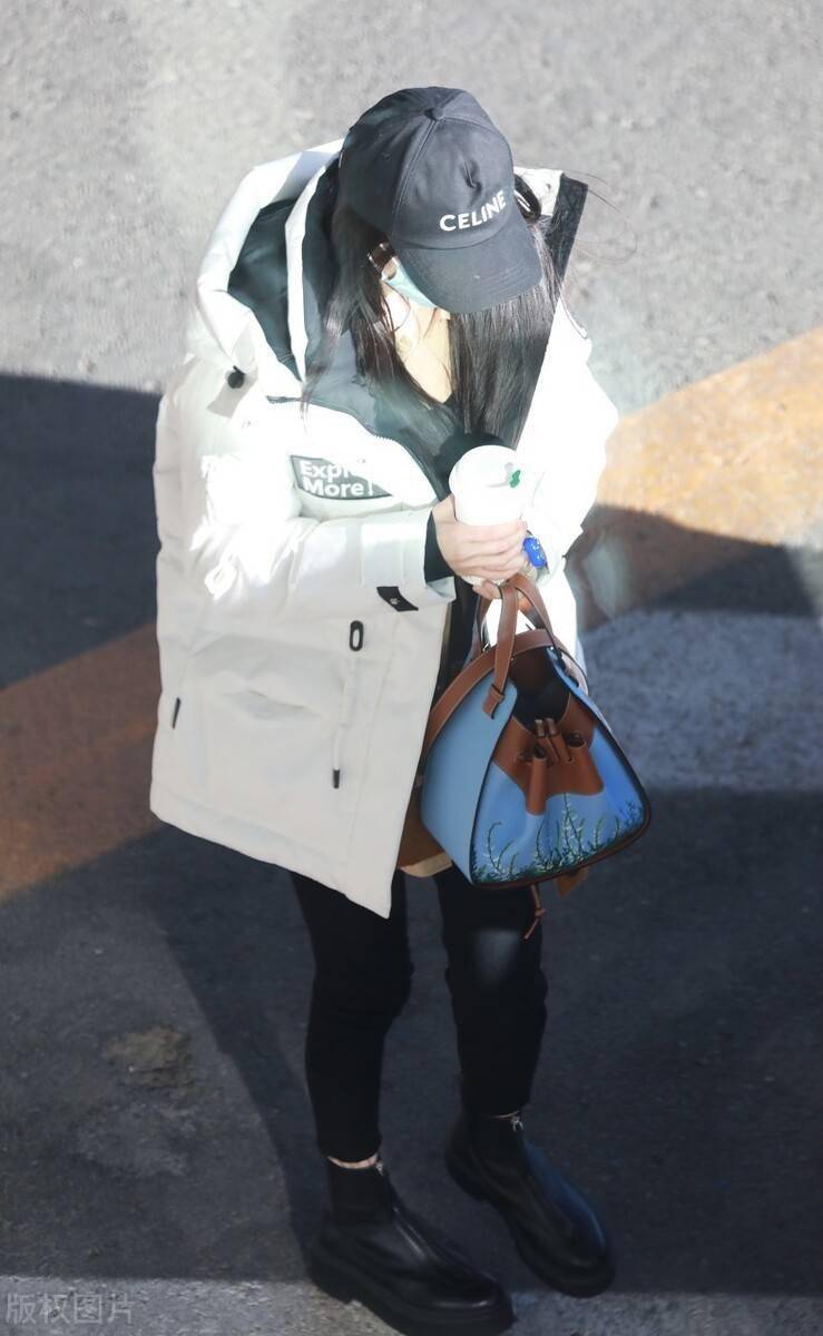 杨幂穿白色长款羽绒服低调现身,头戴黑色棒球帽不失格调_机场