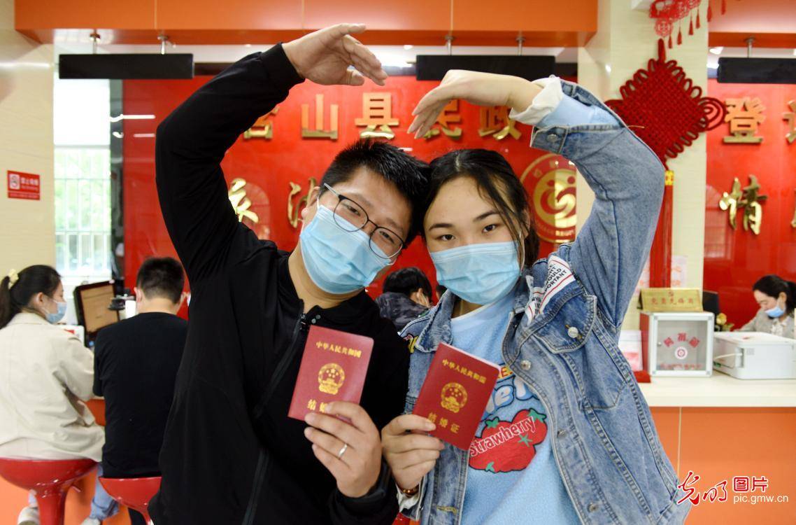 5月20日,安徽省含山县民政局婚姻登记处,情侣们展示着结婚证