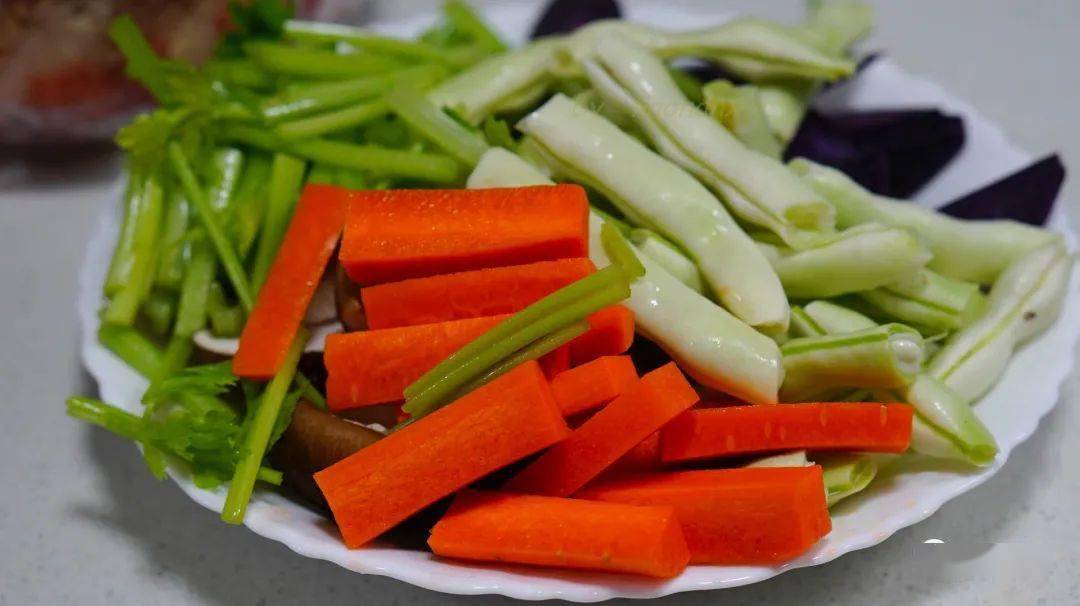 把备好的蔬菜改刀,切成厚片或者粗条备用,芹菜梗和叶分开切.