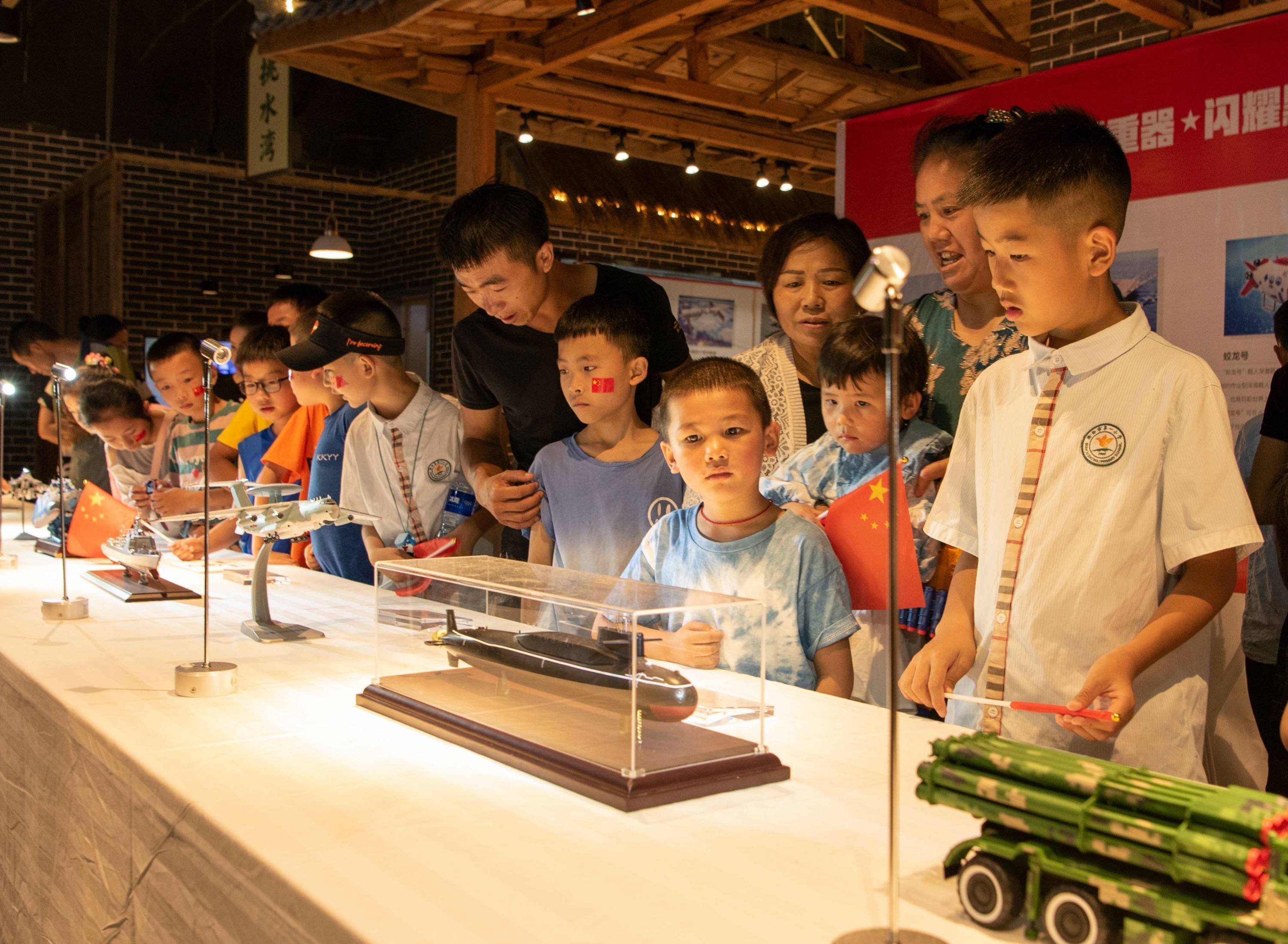 7月11日,小学生在黔西市金街广场国防教育军事模型展览馆里参观,接受