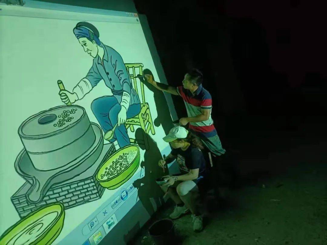 为减轻黄老师工作量,村干利用夜晚时间,照着投影仪投映的画面勾边描廓