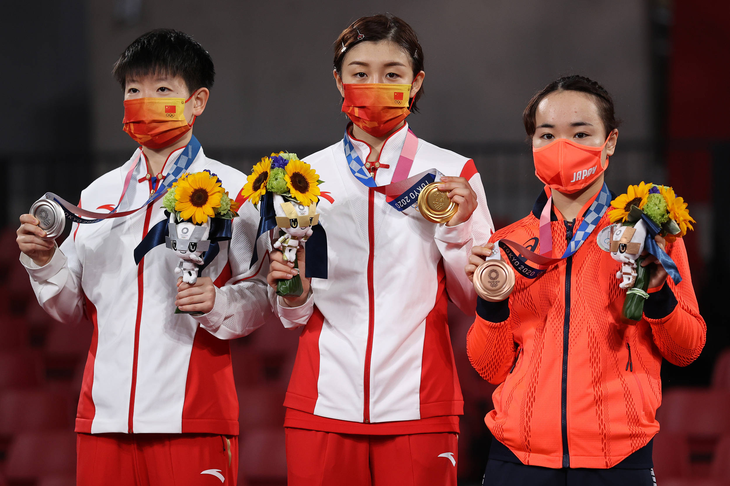 在领奖台上的孙颖莎(左),金牌获得者陈梦与伊藤美诚(右) 图自视觉中国