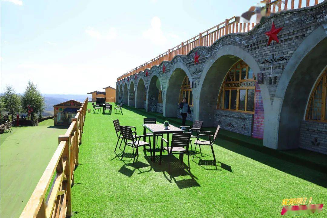 山上窑洞宾馆一字排开,蓝天白云下整齐的青砖窑洞,喜庆的大红灯笼高挂