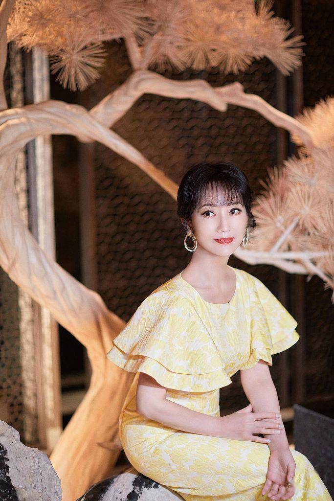 赵雅芝着荷叶袖鹅黄长裙优雅高贵 轻倚金松烘托高雅氛围