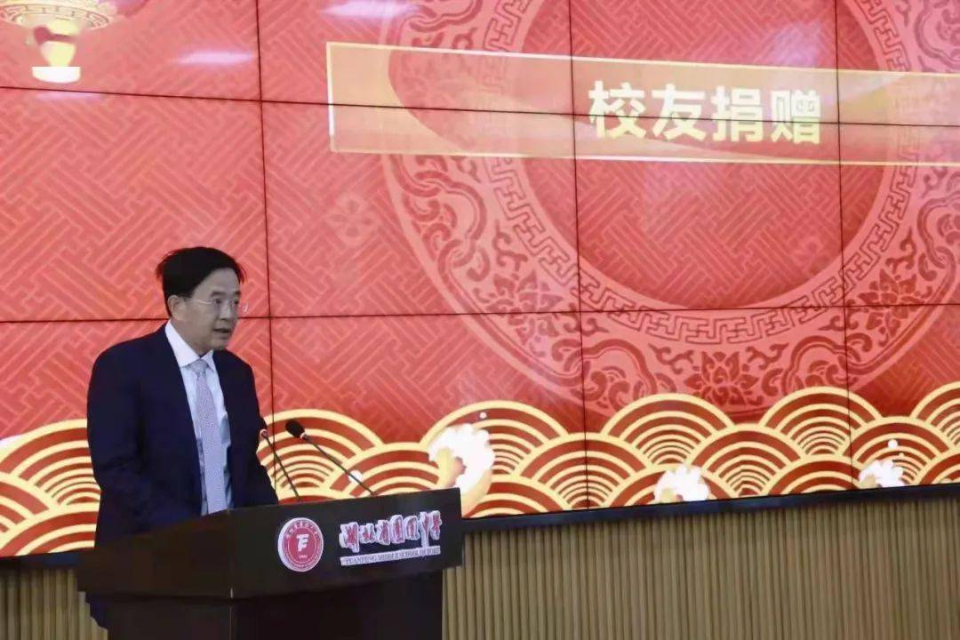 等领导和广大校友的见证下,童重林会长向团风中学校长陈友仁赠牌,童重