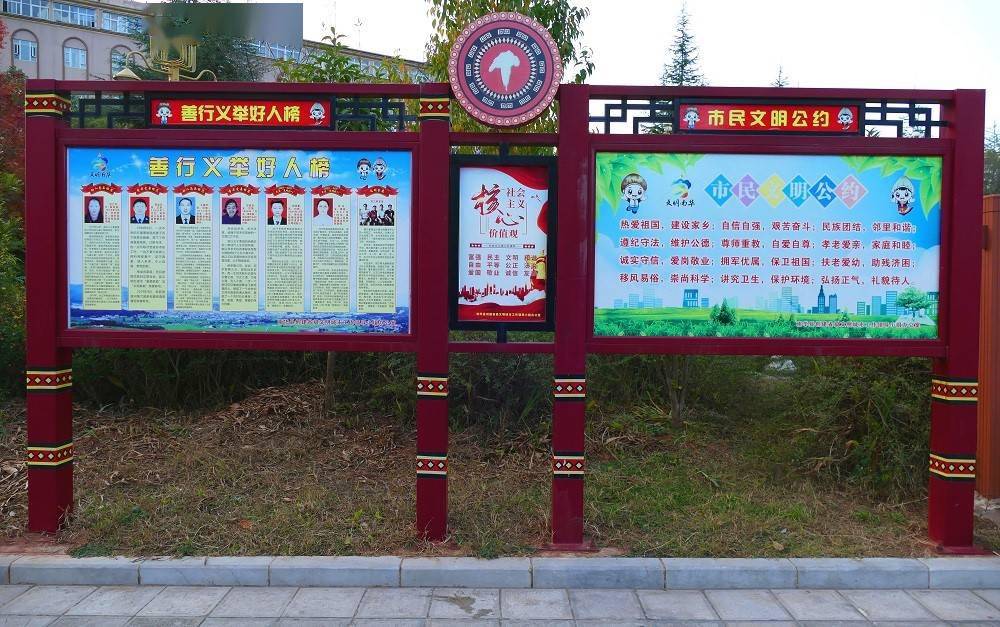 旗海湿地公园,两位老人正在文明城市创建公益广告宣传展牌前驻足观看