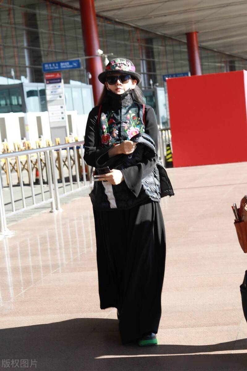 街拍:杨丽萍身穿黑色刺绣马甲搭长裙酷飒个性民族风满满_机场_酷飒_杨