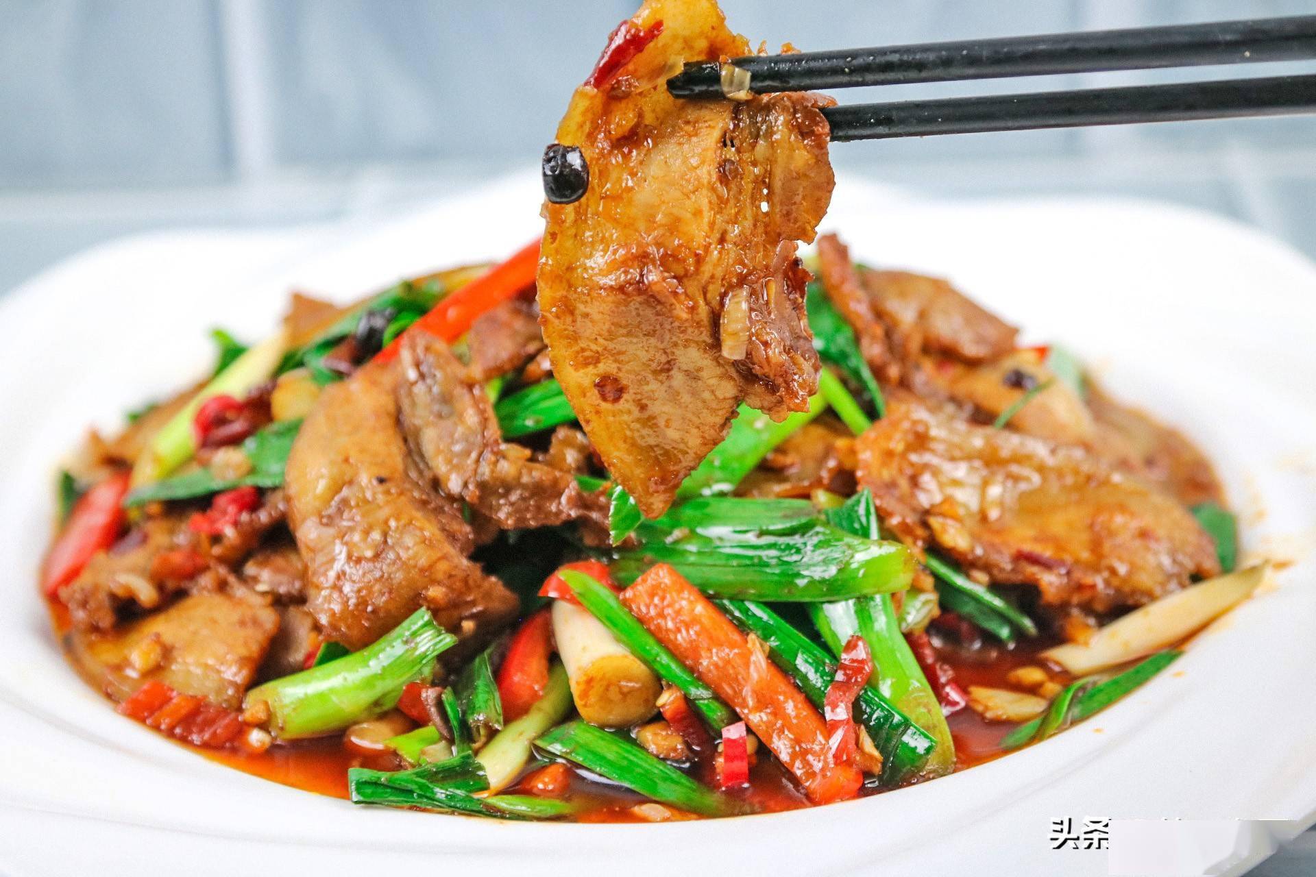 蒜苗回锅肉3,放入青红辣椒,开大火爆炒30秒,把辣椒炒至断生,加入少许