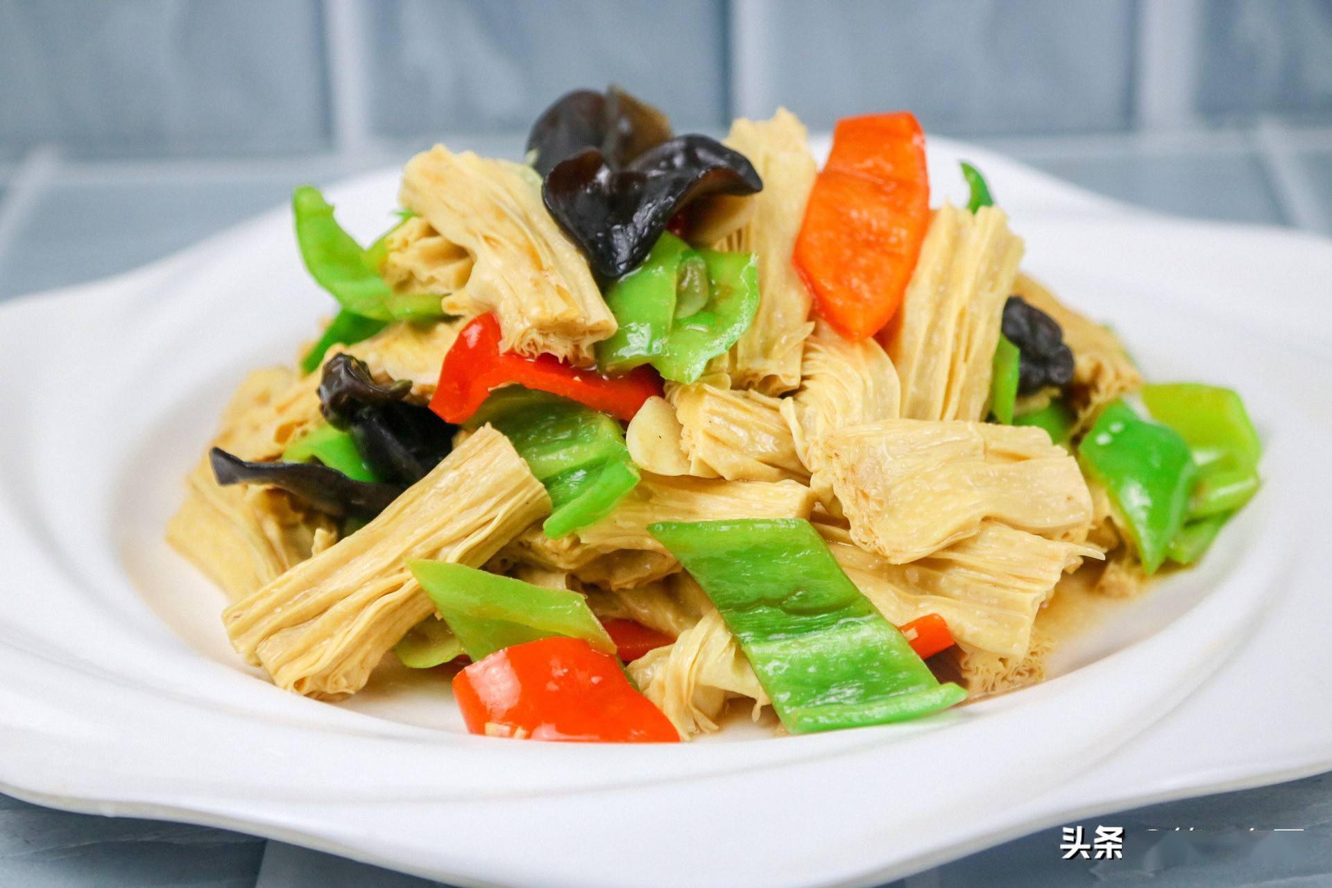 腐竹4两左右提前用温水泡发,切成3厘米长的段,青椒2个切成菱形片,红椒