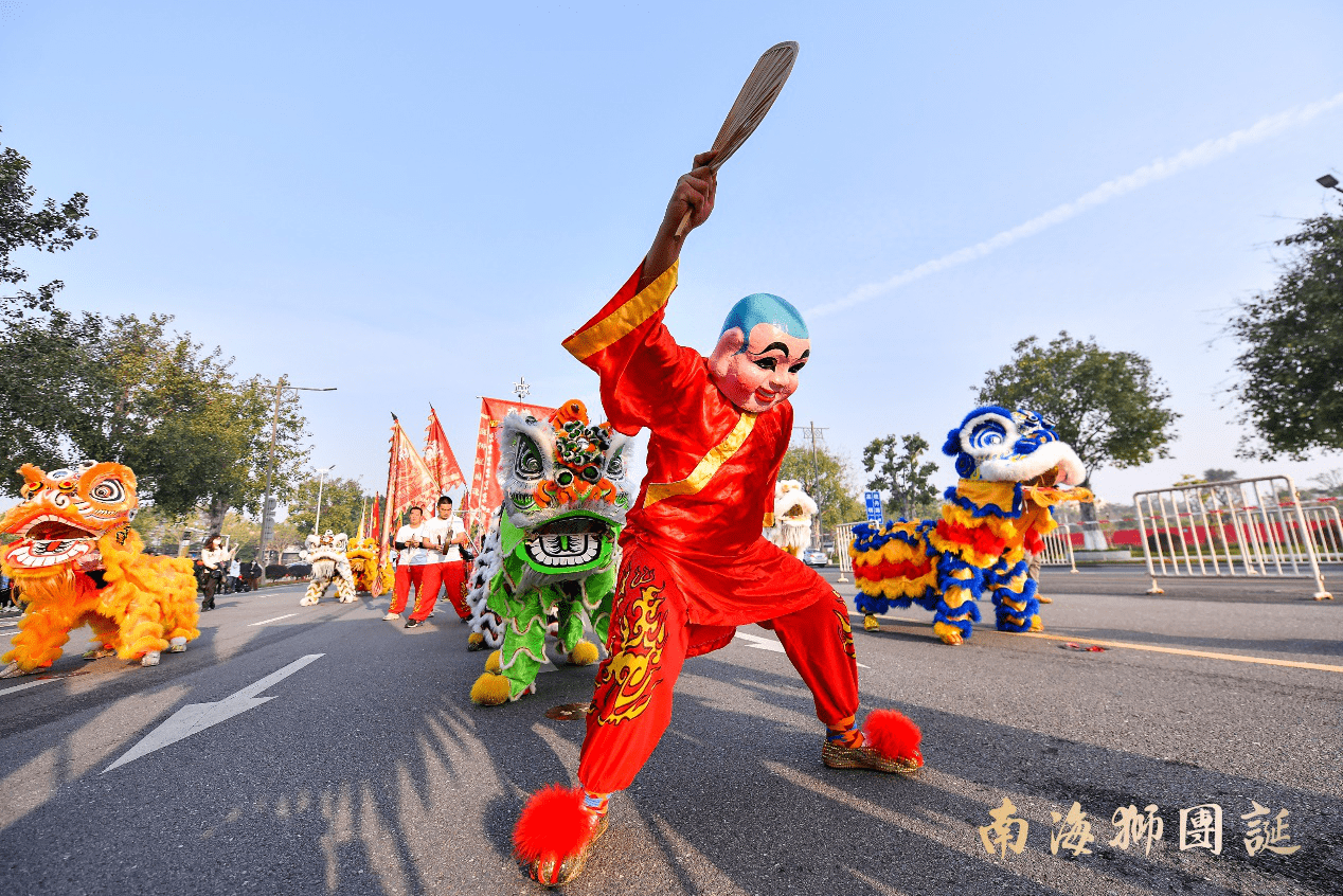 在锣鼓喧天中,迎风飘扬的狮旗,旌旗招展的狮团团旗,喜气洋洋的大头佛