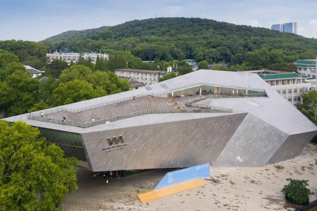 极具极具现代主义风格的万林艺术博物馆,则像一块「飞来石」般屹立