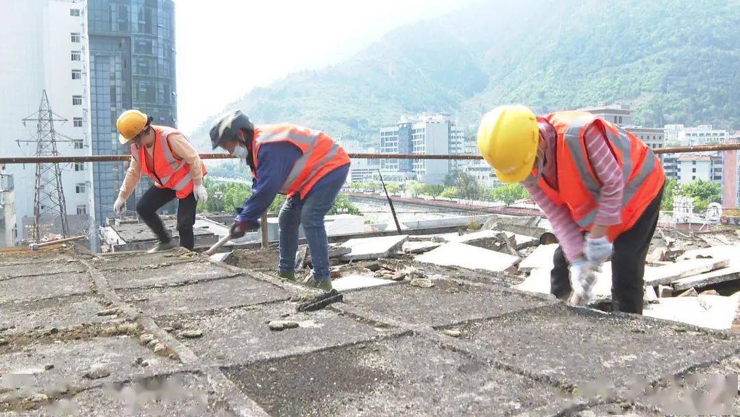 因多年雨水和風力的侵蝕後拆除老化的隔熱板工人們正在小區樓頂記者在