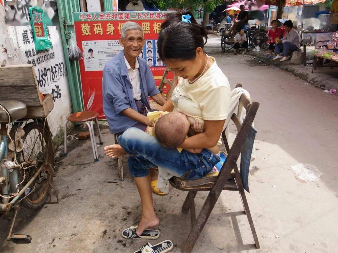 2010年,湛江东海岛,集市理发摊上一位母亲在喂奶