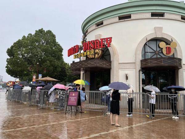 上海迪士尼部分恢复运营，游客冒雨排队进商店，不少人买了星黛露