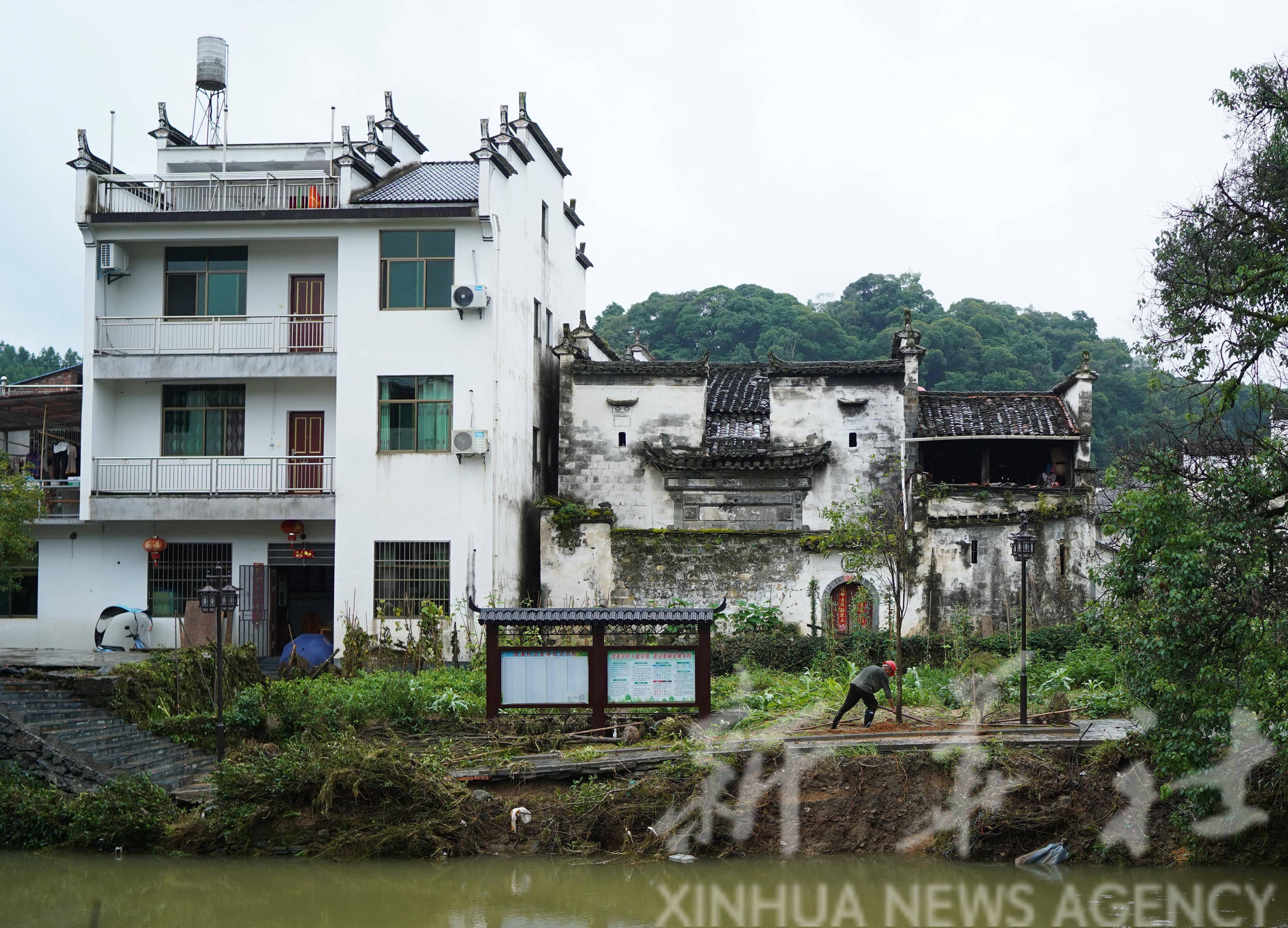 6月22日,村民在婺源县思口镇思溪延村清理洪水留下的垃圾