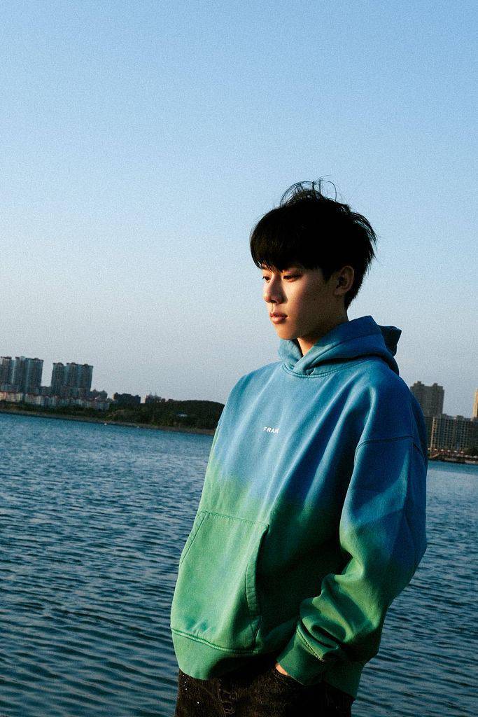 周奇发布海畔潮汐写真穿蓝色卫衣少年感十足