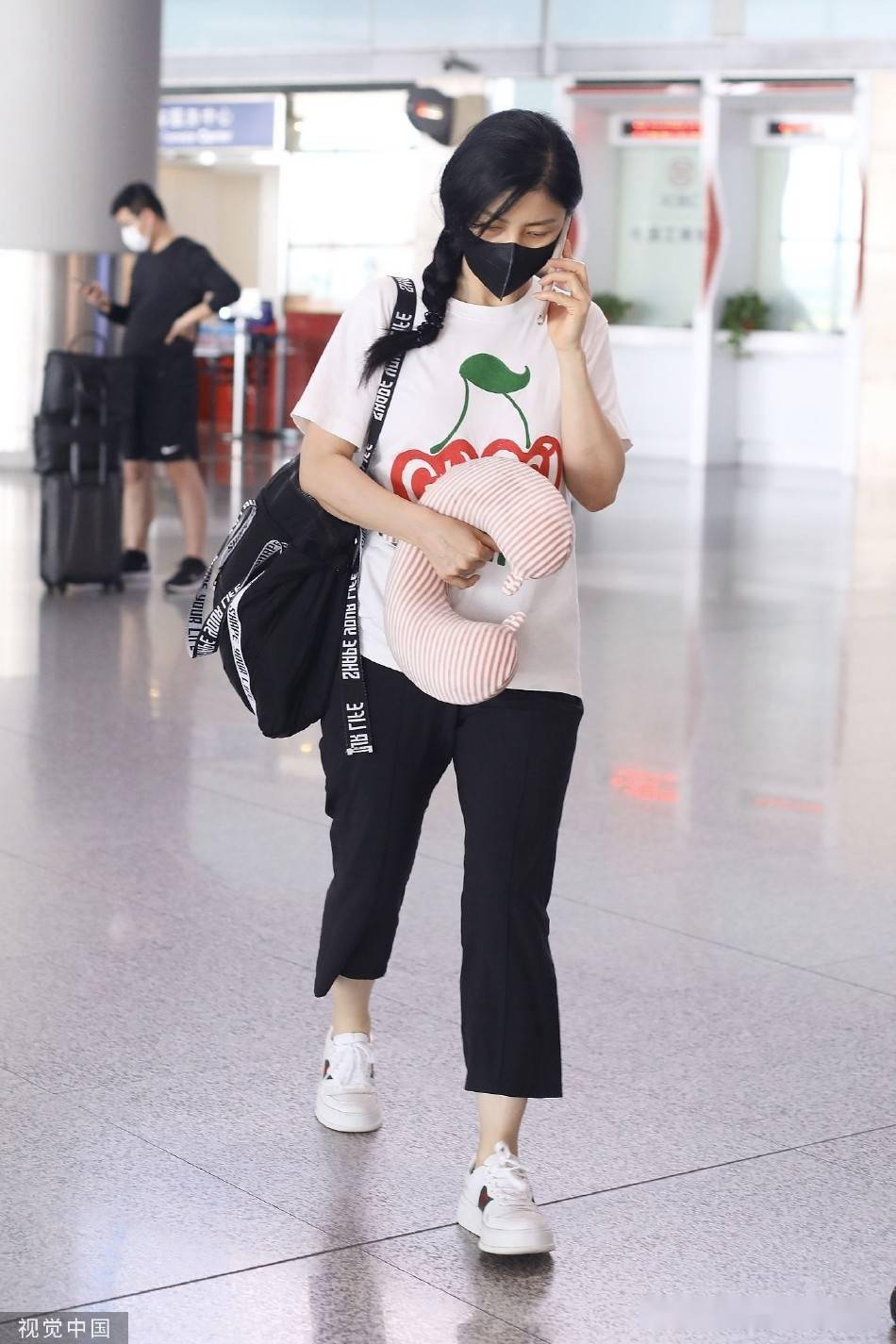 胡可手拿按摩枕现身机场穿印花t恤麻花辫造型显少女感