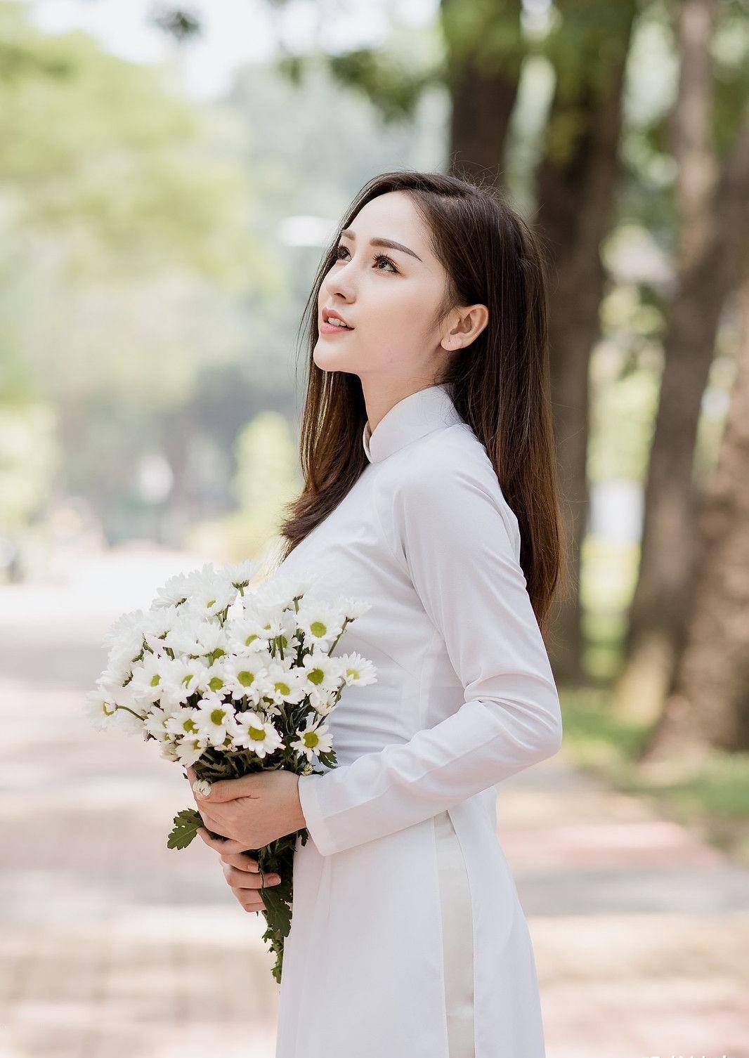 手捧鲜花,身穿白色奥黛,气质温婉,笑容阳光的国外姑娘真美_一笑_美女