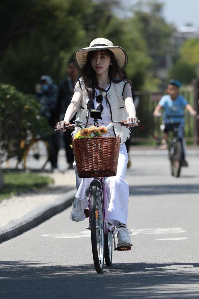王心凌《星星的约定》节目路透曝光 戴遮阳帽云南街头骑脚踏车_马甲