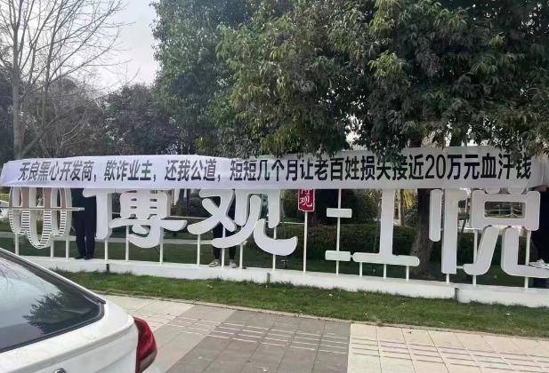 条幅上写着,无良开发商,欺诈业主,短短几个月让老百姓损失接近20万元