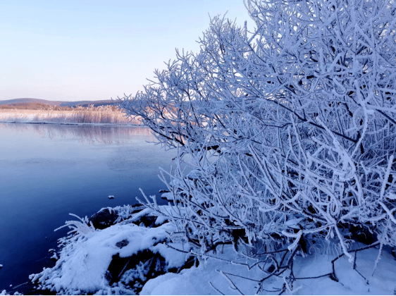 清澈的湖水掩映在雪山冰掛之間,湖面蒸汽嫋嫋,氤氳空靈;蕩竹排於其間