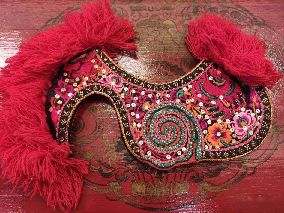 绣有精美的花鸟图案和旋涡状祥云纹,用金线,亮片作装饰西山区团结彝族