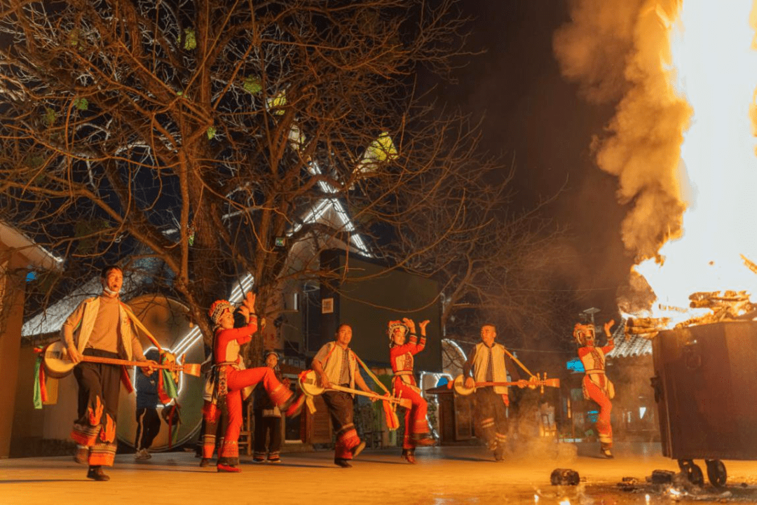 游客和村民一起围绕篝火跳起"阿细跳月"三弦制作传承人正在制作"阿细