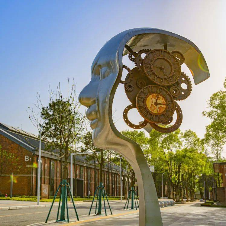 漫步园区,映入眼帘的是座座红砖砌成的办公厂房,树木绿地,工业雕塑