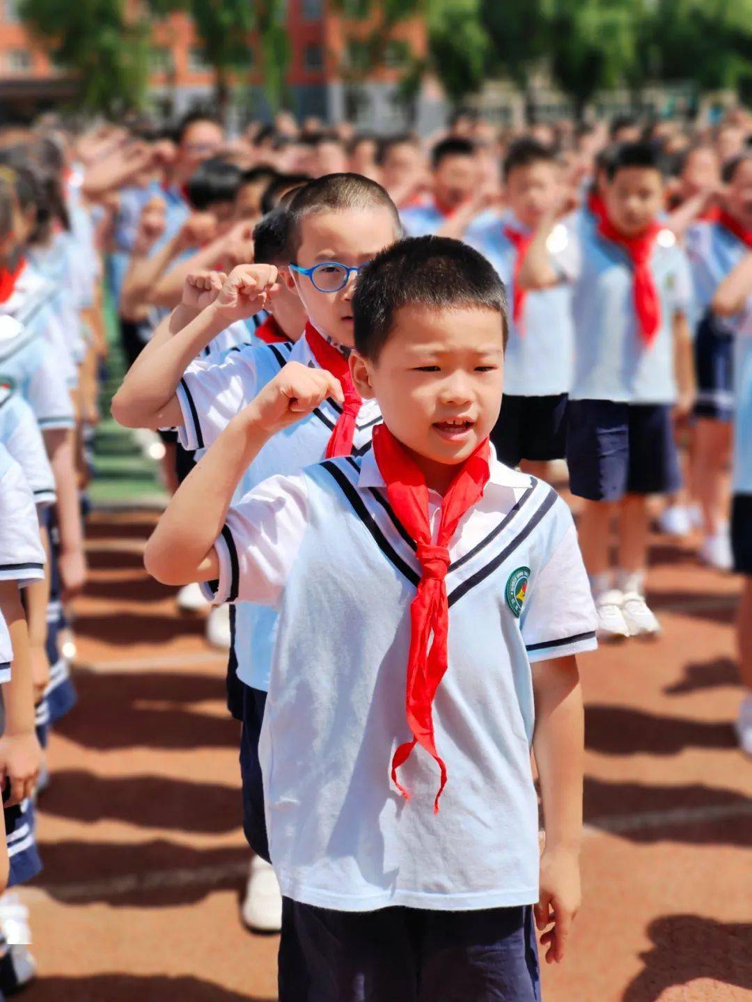 红岩小学大队长冯籽诺同学带领新队员在队旗下庄严宣誓,随着朝气蓬勃
