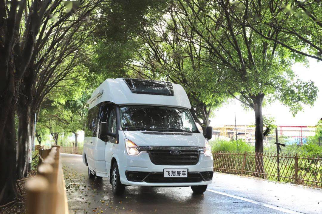 的白色车身,没有过多的拉花设计,精简大气,车身配置了房车专用中门,后