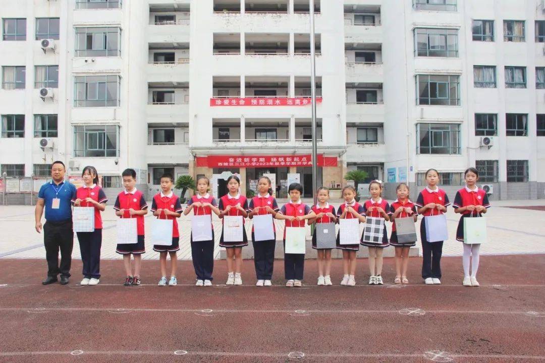 开学典礼上,樵湖岭小学校长李华明为学生派送"开学嘉年华"大礼包.