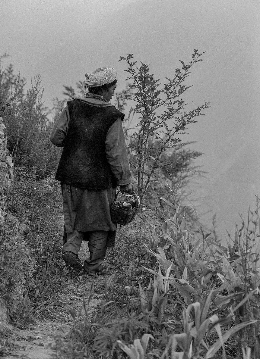 羌族妇女周文珍手提香蜡纸钱前往祭奠逝去的亲人.