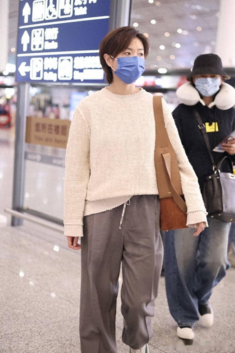 街拍:万茜米白色针织衫 灰色老爹西裤 麂皮单肩包轻松随性_北京_机场