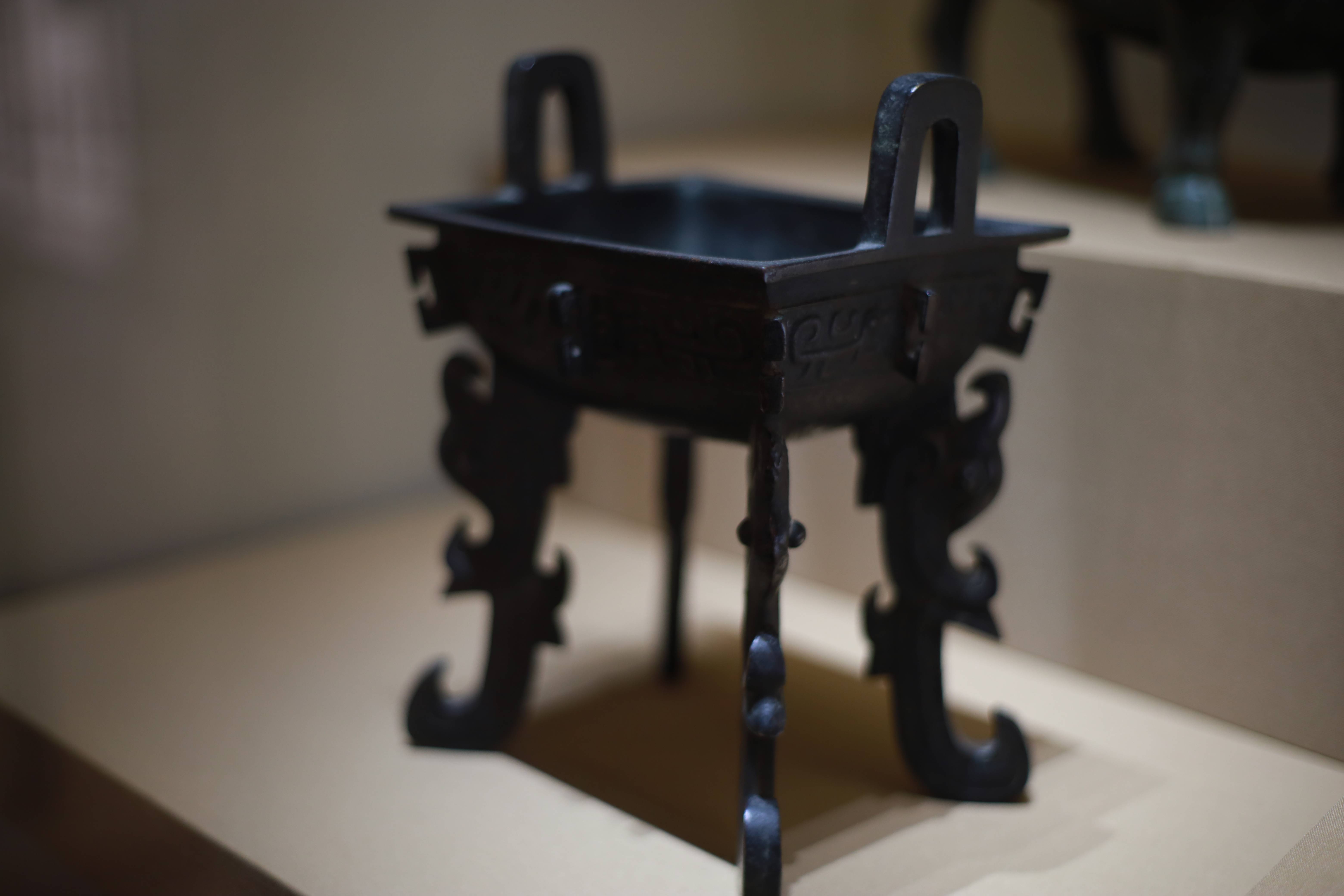 式,两方耳直立微外撇,方口折沿,浅腹下敛,圜底,腹部外壁饰两两对称的