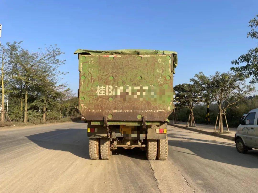 发现一辆绿皮渣土车行驶在路上,该车车轮带泥污染了路面